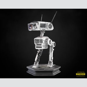 以下が含まれることがあります： カメラとアンテナが付いた白い関節式ロボット。ロボットは「STAR WARS」という文字が書かれた黒い台座の上に立っています。