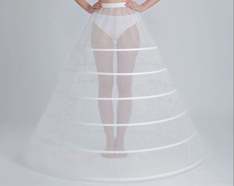 May include: A white tulle petticoat with five layers and a satin ribbon trim. The petticoat is designed to create a full, flowing skirt.