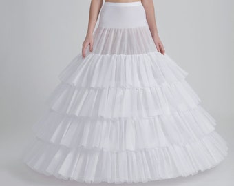 Puede incluir: Un enaguas de tul blanco con múltiples capas de volantes. El enaguas está diseñado para agregar volumen y forma a una falda o vestido.