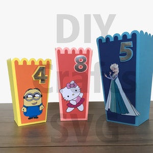 Puede incluir: Tres cajas de cartón de colores con bordes festoneados, cada una con un personaje y un número diferentes. Las cajas están decoradas con un minion, Hello Kitty y Elsa de Frozen. Los números en las cajas son 4, 8 y 5.