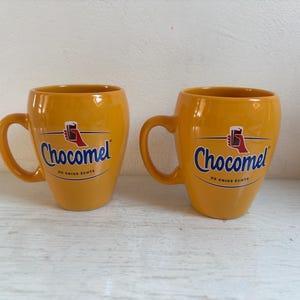 Set of two Chocomel cups, Nutricia, hot chocolate, logo on one side, handle on the left