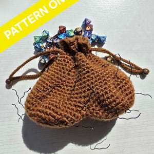 May include: A brown crocheted dice bag with a drawstring closure. The bag is filled with colorful polyhedral dice.