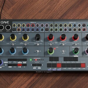 Könnte beinhalten: Ein grauer Synthesizer mit zahlreichen Knöpfen, Reglern und Ein-/Ausgangsbuchsen. Das Gerät hat einen dunklen Rahmen und trägt die Aufschrift "Crave" und "behringer". Die Bedienelemente sind mit Begriffen wie "VCO", "LFO" und "Envelope" beschriftet.