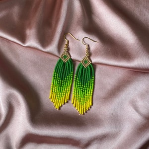 Op de afbeelding: Een paar groene en gele kralen oorbellen met gouden haakjes. De oorbellen zijn ombre, van groen naar geel.