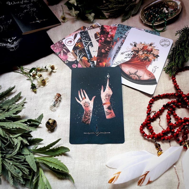 Puede incluir: Una carta de tarot con un fondo azul oscuro y dos manos que se estiran hacia una luna creciente. Las manos est&aacute;n adornadas con intrincados tatuajes, incluyendo un sol y una luna creciente. La carta es parte de una baraja de tarot con un tema m&iacute;stico.