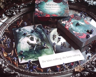 May include: A deck of Mirror of Mama Shamana metaphor cards featuring dark, forest-themed illustrations, a box with the title, and a white card with the text She takes nothing, she bares nothing, all arranged on a silver-toned decorative tray.