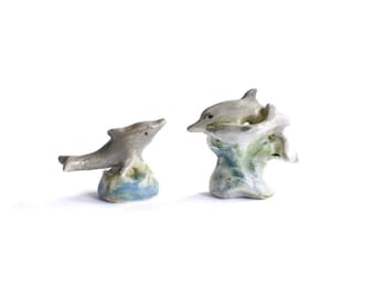 Un par de figuras de delfines de porcelana