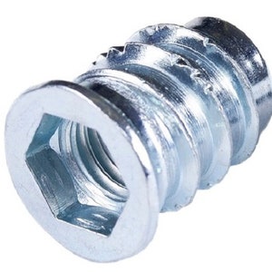 May include: Silver-toned metal insert nut with a hexagonal opening and a threaded outer edge. The insert nut is designed for use with wood or other materials.