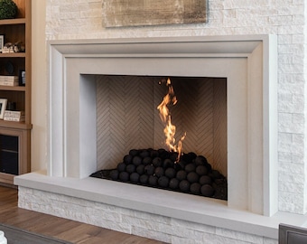 May include: A modern living room with a white brick fireplace, a large abstract painting above the fireplace, and a gray couch in the foreground.
