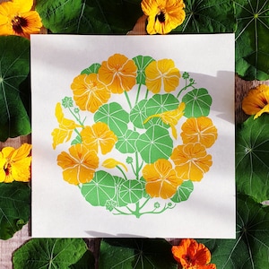 Op de afbeelding: Een print van een gele goudsbloem met groene bladeren. De bloem bloeit en heeft een gele kern. De bladeren zijn groen en hebben een getextureerd oppervlak.