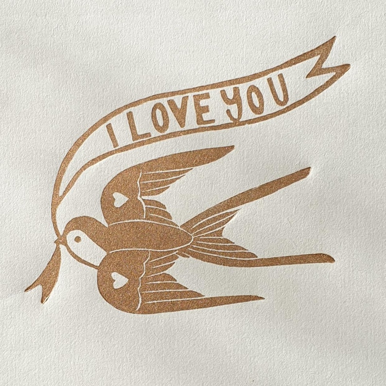 Op de afbeelding: Een bruin silhouet van twee vogels die vliegen met een banner waarop "I LOVE YOU" staat.