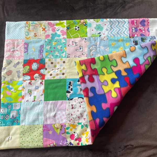 Patchwork quilt perfect size for baby. Each flannel square cut and sewn together with fleece backing and a layer of batting.