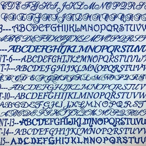 May include: A digital display showing fifteen distinct blue font styles labeled FONT-1 through FONT-15. Each line presents the full uppercase English alphabet from A to Z in a unique typeface, ranging from cursive and script styles to block lettering.