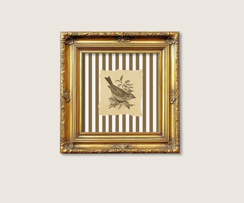 Op de afbeelding: Een vierkante, sierlijke gouden lijst omringt een print in vintage-stijl. De print toont een gedetailleerde zwart-wit illustratie van een vogel op een tak, tegen een gestreepte achtergrond. De lijst heeft decoratieve gravures.