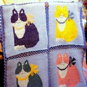 Puede incluir: Un conjunto de cuatro cojines cuadrados de ganchillo, cada uno con un gato de diferente color: morado, amarillo, verde y rosa. Los gatos tienen lazos y están sobre un fondo azul claro con un borde morado.