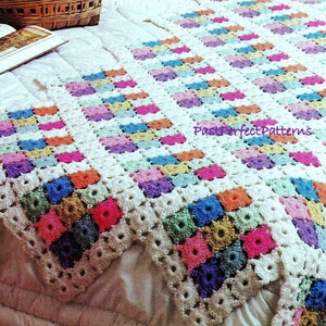 Könnte beinhalten: Eine gehäkelte Decke mit weißem Hintergrund und bunten Quadraten. Die Decke ist mit einem Granny-Square-Muster gearbeitet und hat eine strukturierte Optik. Der Text "PastPerfectPatterns" ist in der rechten unteren Ecke des Bildes sichtbar.