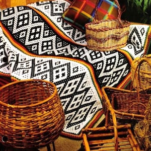 May include: A black and white crocheted throw blanket with a geometric pattern. The blanket is draped over a wicker basket and a wooden chair.