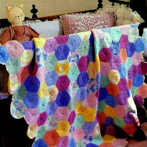 May include: A colorful crocheted baby blanket with a scalloped edge. The blanket is made of multiple hexagons in shades of pink, purple, blue, yellow, and green.