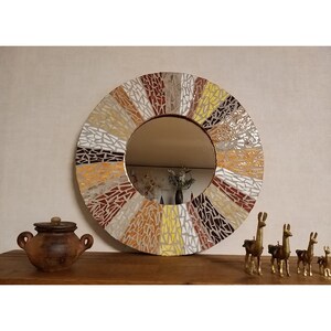 Doughnut shaped mirror decorated in mosaics red - orange - yellow- beige- brown
