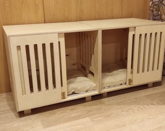 May include: Two wooden dog crates with sliding doors and a white cushion inside each crate. The crates are made of light wood and have a natural finish.