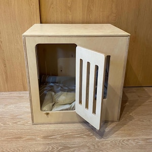 Modern dog crate with hinged door with a latch. Dog kennel, dog house, dog bed, indoor dog house, dog furniture, dog cage. Natural wood.