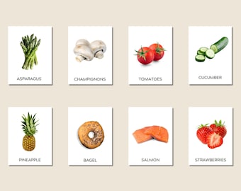 Puede incluir: Un conjunto de ocho tarjetas con imágenes y texto. Las tarjetas presentan diversos alimentos e ingredientes, incluyendo espárragos, champiñones, tomates, pepino, piña, un bagel, salmón y fresas.
