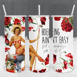 May include: A white tumbler with a straw featuring a vintage-style illustration. The design includes a woman in a red and white checkered bikini, red flowers, and the text "Hoeing Ain't Easy But Somebody's Gotta Do It!"