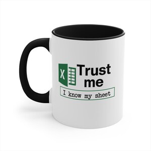 May include: White ceramic coffee mug with a black rim and handle. The mug features a green Excel logo and the text "Trust me I know my sheet".