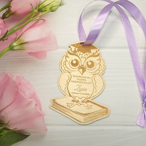 May include: Wooden owl figurine with a graduation cap, holding a book. The owl is decorated with the text "Pasowanie na ucznia pierwszej klasy" and the name "Zosia" with the date "01.06.2022".