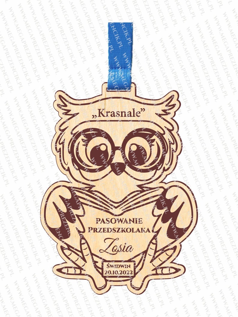 May include: A wooden owl figurine with large glasses and a book in its hands. The owl is holding a sign that says "Pasowanie Przedszkolaka Losia Świdwin 20.10.2022".