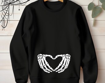 May include: Black sweatshirt with a white skeleton hand design making a heart shape on the front.