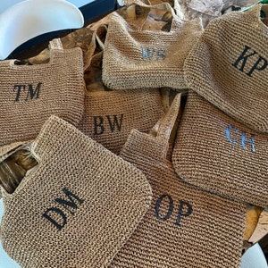 May include: Seven straw tote bags with different initials embroidered on them. The initials are TM, BW, DM, OP, CH, KP, and WS.