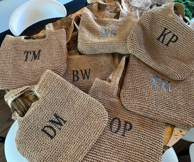 May include: Seven straw tote bags with different initials embroidered on them. The initials are TM, BW, DM, OP, CH, KP, and WS.