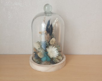 Gedroogde en geconserveerde bloemen in een glazen stolp.