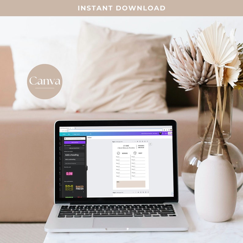 May include: A laptop computer displaying a Canva design template for a "Chore Chart and Routine" planner. The template includes sections for "Morning", "Work", and "Night" with space for writing tasks. The laptop is on a white table with a vase of dried flowers.