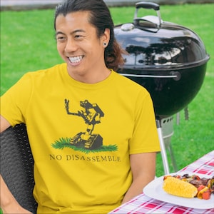 May include: A yellow t-shirt with a black and white graphic of a robot with the text "NO DISASSEMBLE".