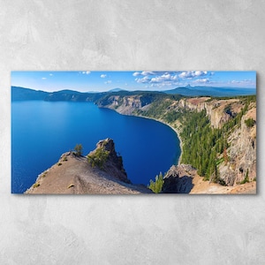 May include: A panoramic view of a deep blue lake surrounded by rocky cliffs and lush green trees. The lake is calm and reflects the blue sky.