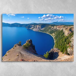 May include: A panoramic view of a deep blue lake surrounded by rocky cliffs and lush green trees. The lake is calm and reflects the blue sky. The cliffs are rugged and have a brown and gray color. The trees are green and dense. The image is taken from a high vantage point, looking down at the lake.