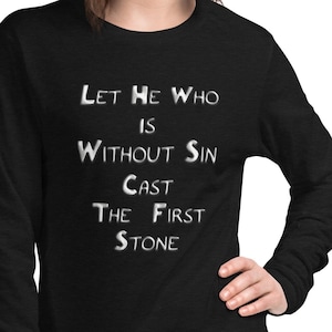 May include: Black long-sleeve shirt with white text that reads "Let he who is without sin cast the first stone."