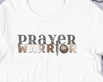 May include: White t-shirt with the words "Prayer Warrior" printed in black and brown letters with a sword graphic in the middle.