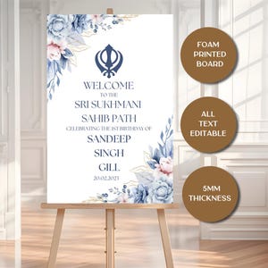 Puede incluir: Un letrero blanco sobre un caballete, con detalles florales y dorados. El letrero dice "WELCOME TO THE SRI SUKHMANI SAHIB PATH CELEBRATING THE 1ST BIRTHAY OF SANDEEP SINGH GILL 20.02.2023". El texto es editable y tiene 5 mm de grosor.