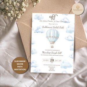 May include: A light blue and beige invitation card for a Sukhmani Sahib Path celebration. The card features a watercolor hot air balloon design, clouds, and text. The invitation is for Mandeep Singh Gill's 1st birthday, July 29, 2024.