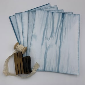 Papeles teñidos con efecto tie-dye en verde azulado para revistas basura, fabricación de tarjetas y otras manualidades con papel