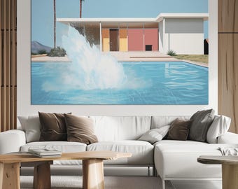May include: A large rectangular wall art print featuring a mid-century modern house with a flat roof, two palm trees, and a bright blue swimming pool with a large white water splash in the center, set against a clear light blue sky background.
