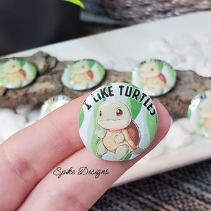 May include: A green and white button with a cartoon turtle and the text "I like turtles".