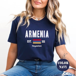 May include: A navy blue t-shirt with white text that reads "Armenia Est. 301 Hayastan" and a small image of the Armenian flag.