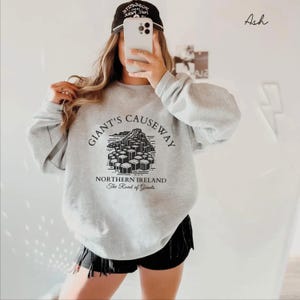 May include: Gray sweatshirt with a black graphic of the Giant's Causeway in Northern Ireland. The graphic includes the text "Giant's Causeway", "Northern Ireland", and "The Road of Giants".