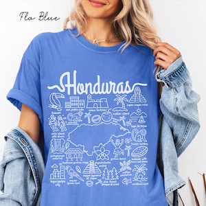 Peut inclure: Un t-shirt bleu avec une impression graphique blanche représentant une carte du Honduras entourée d'illustrations au trait de monuments, de faune et d'icônes culturelles locales, avec le texte Honduras et diverses étiquettes en police blanche.