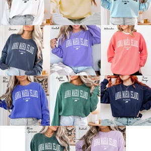 May include: A collection of long-sleeved sweatshirts in various colors, each featuring the text "ANNA MARIA ISLAND FLORIDA" in a bold, white font. The sweatshirts are in shades like white, yellow, blue, green, and purple.