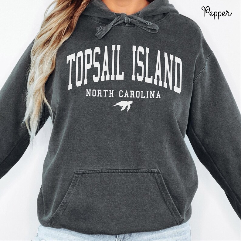 May include: Dark gray hoodie with the text "TOPSAIL ISLAND NORTH CAROLINA" in white block letters. A white turtle graphic is below the text. The hoodie has a drawstring hood and a front pocket.